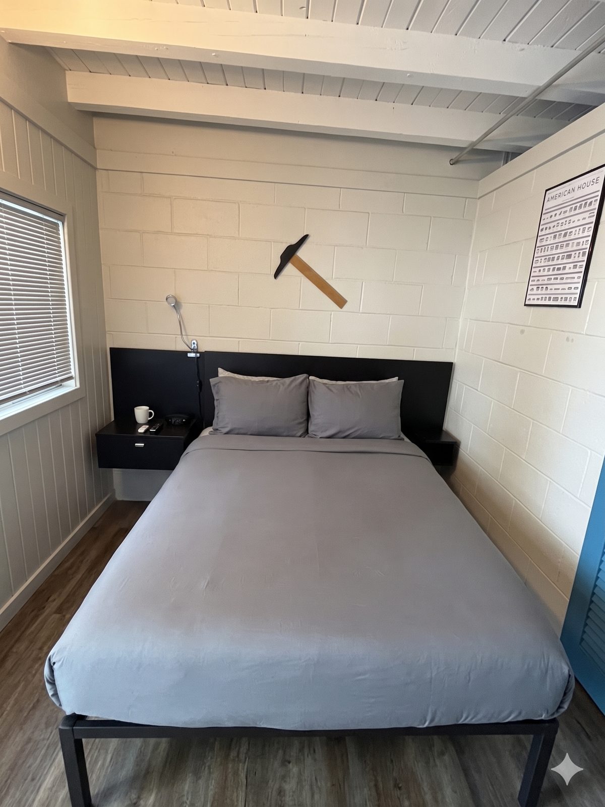 The Architect’s Suite — queen bed with crisp linens against a deep teal accent wall