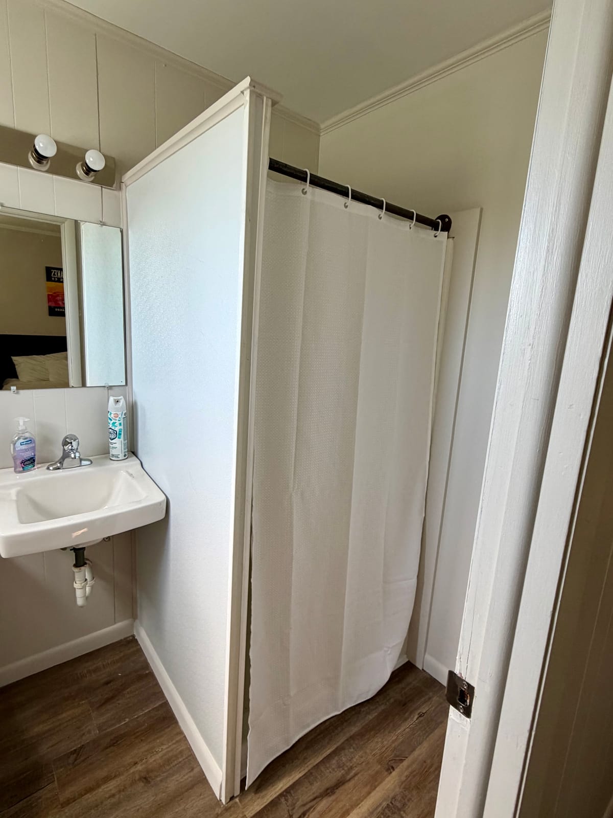The Brewmaster's Room — private en-suite bathroom with white shower curtain and pedestal sink