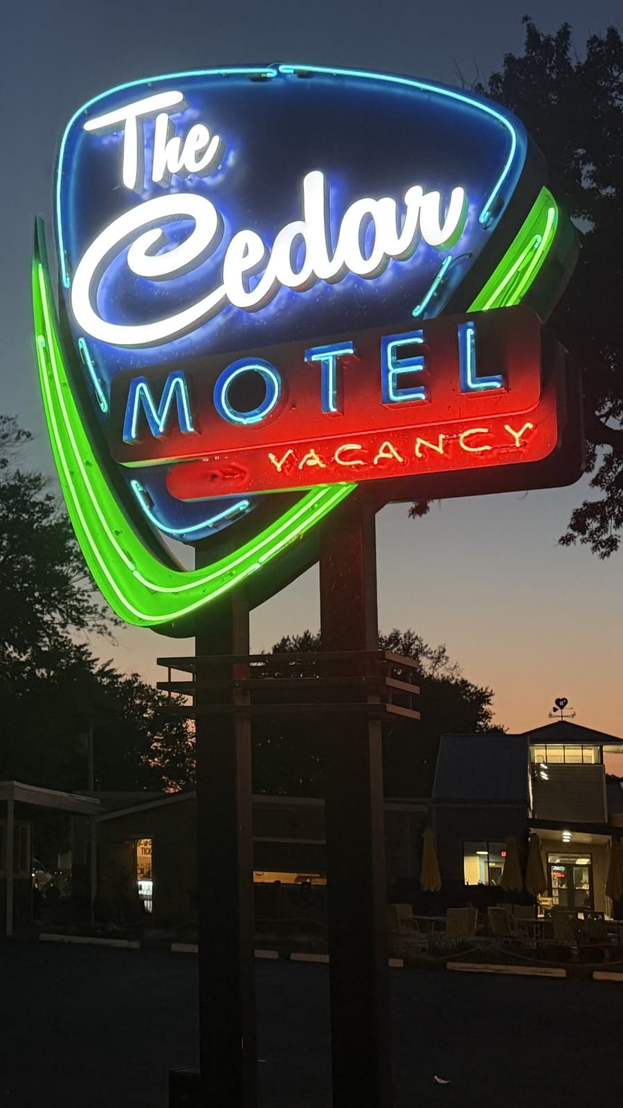 The Cedar's vintage neon sign glowing at dusk over the micro resort in Bay View, Ohio