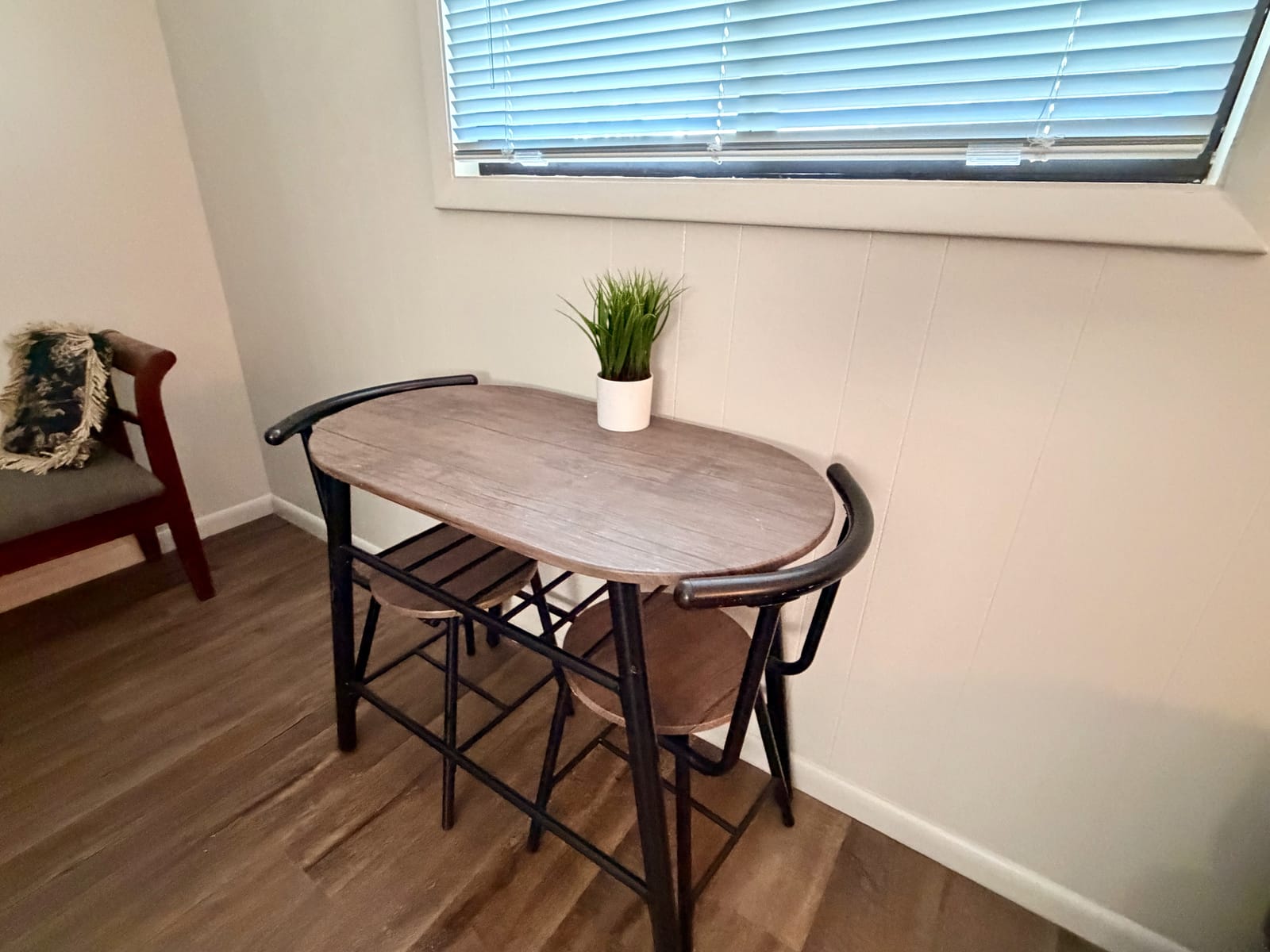 The Garden Room — bistro-style café table with chairs and a small potted plant, perfect for morning coffee