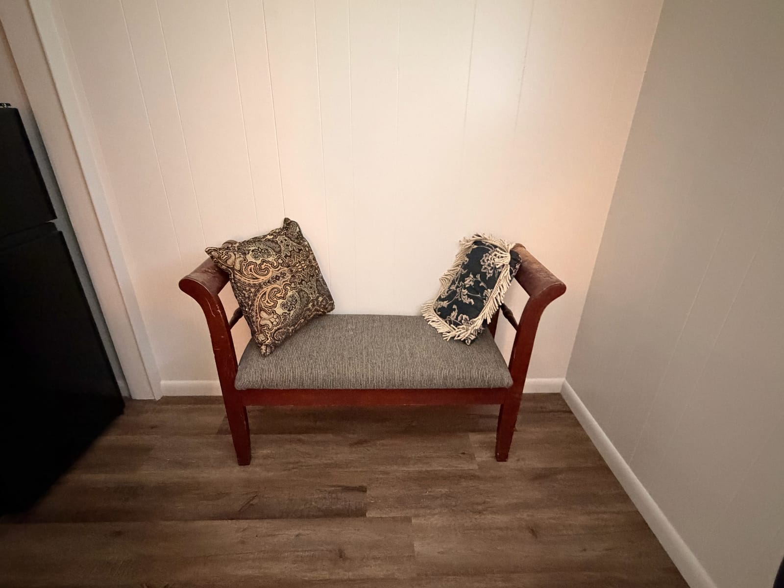 The Garden Room — vintage wood bench seating with patterned throw pillows in cozy corner nook