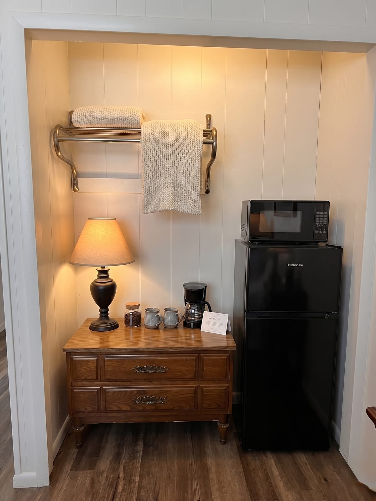 The Garden Room — vintage wood dresser nook with lamp, coffee station, mugs, mini-fridge, and microwave