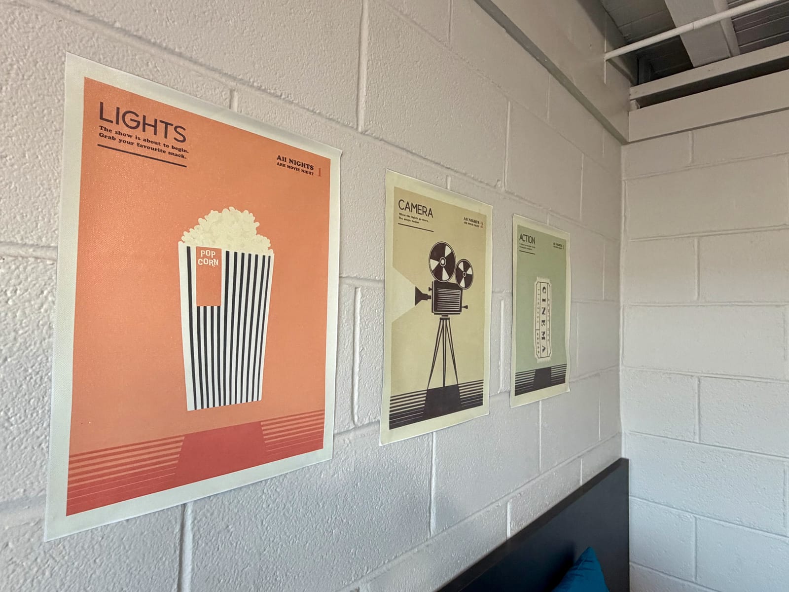 The Movie Room — framed Lights, Camera, Action trio of minimalist movie theater posters on a white brick wall