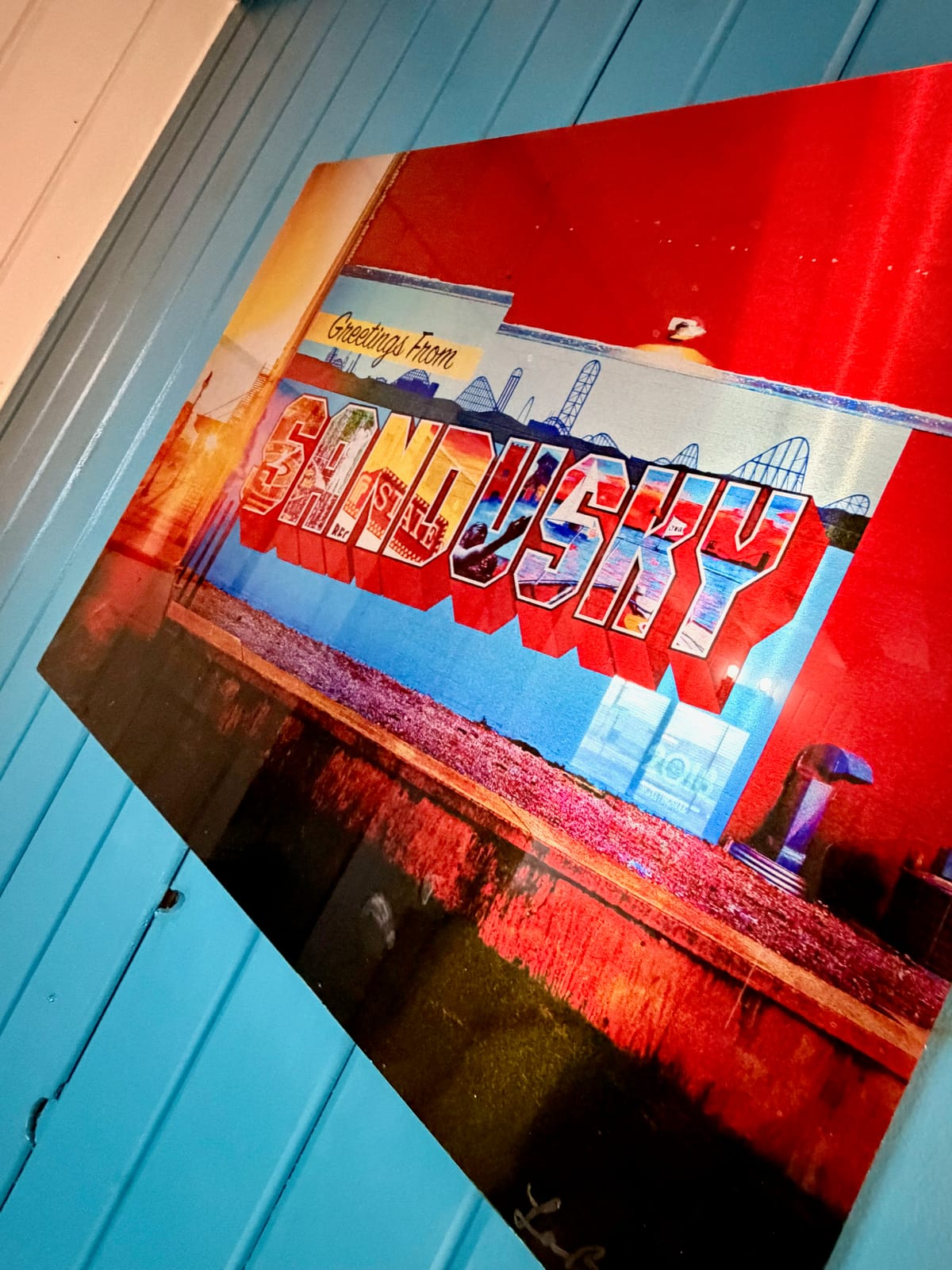 The Movie Room — Greetings from Sandusky vintage postcard-style print on teal shiplap accent wall