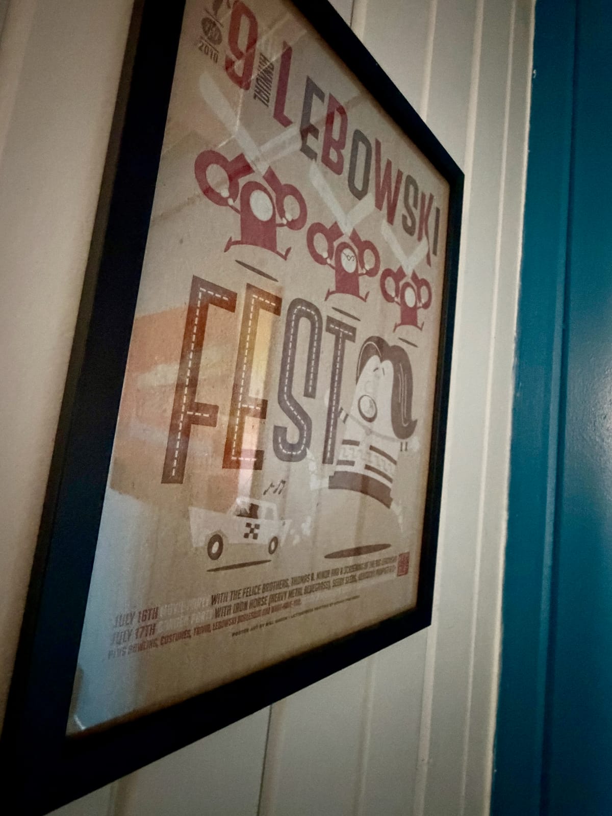 The Movie Room — framed vintage Big Lebowski Lebowski Fest poster on white paneled wall
