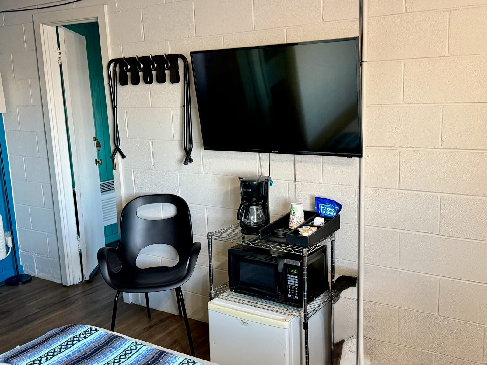 The Movie Room — wall-mounted flat-screen TV with coffee maker, microwave, mini-fridge, and modern chair
