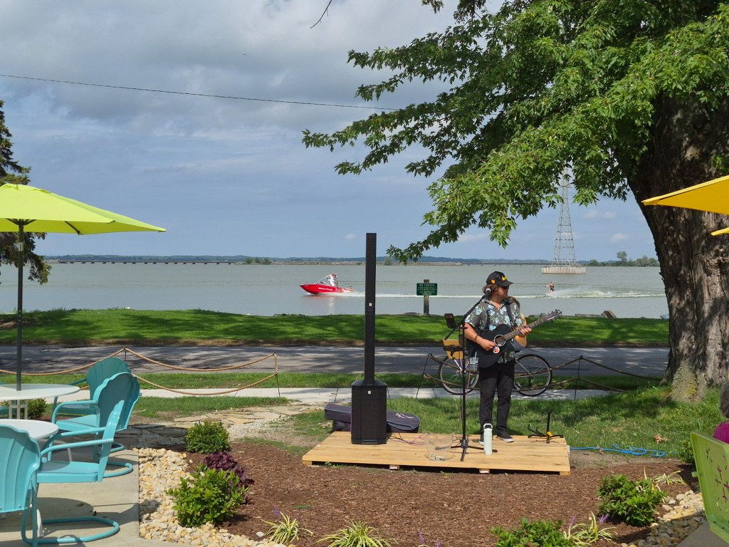 Live music on the waterfront patio at Tique's Bar — Sandusky Bay across the lane