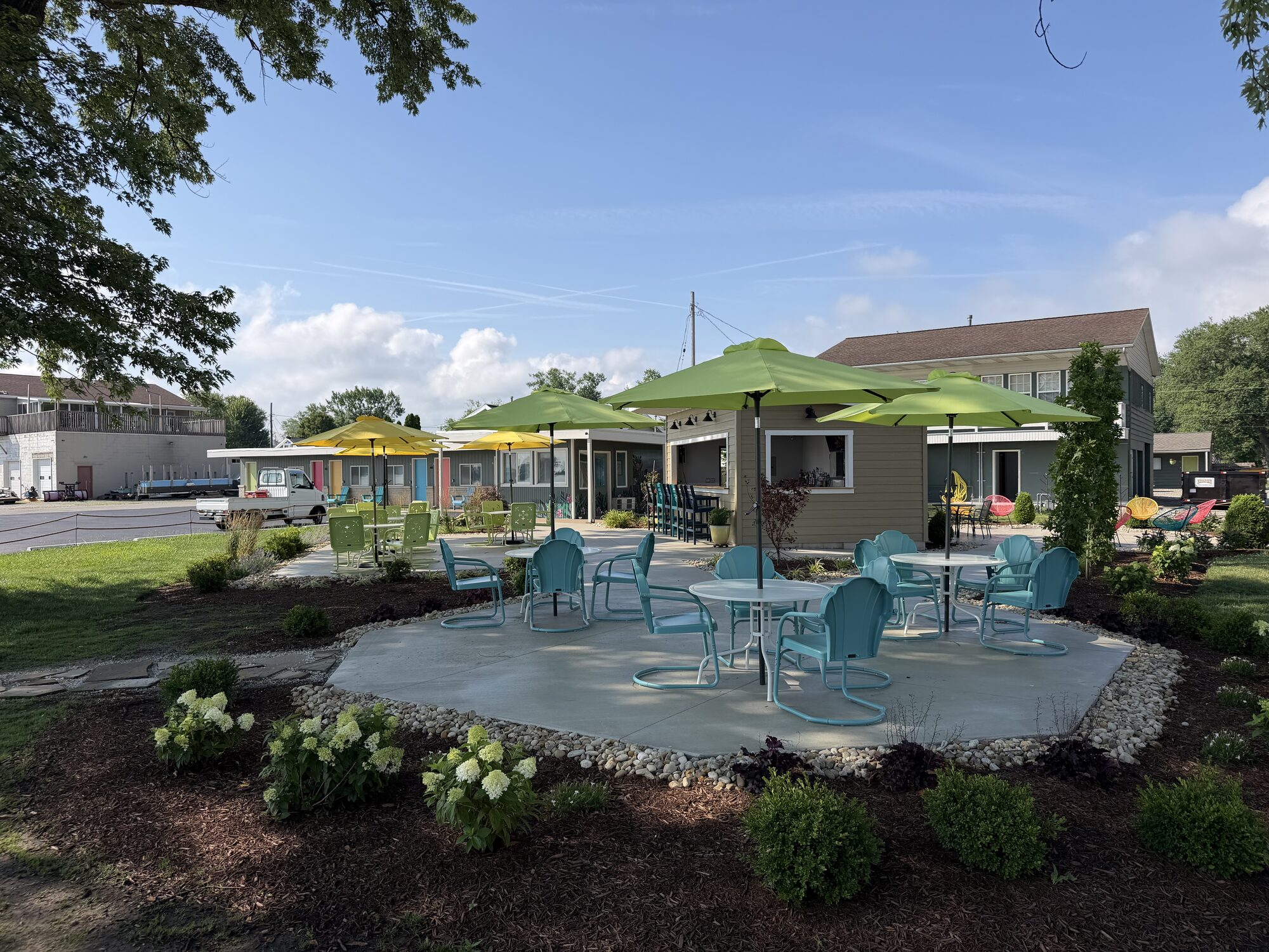 Tique's Bar patio — vintage turquoise chairs under green umbrellas