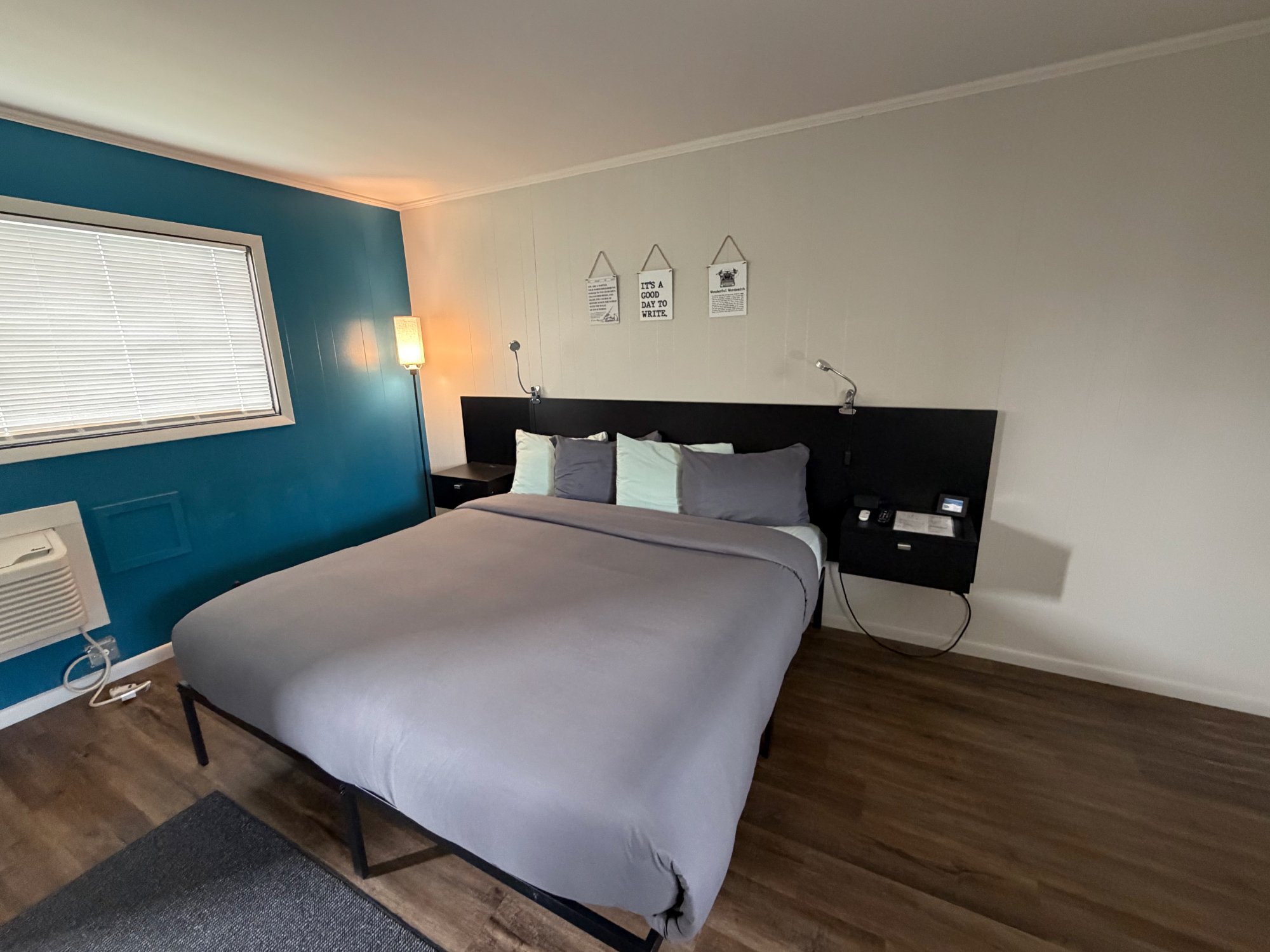 Queen bed in a furnished themed room at The Cedar